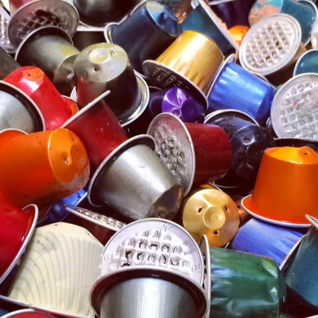 A large pile of discarded aluminium coffee capsules, illustrating why Urban Brew doesn't use aluminium